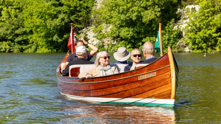 Visitors enjoying a boat ride on Liddesdale on the River Thames with Boating at Cliveden.